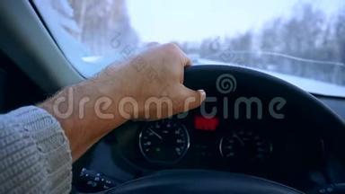 在汽车驾驶过程中，用双手特写方向盘。 冬季公路行驶。